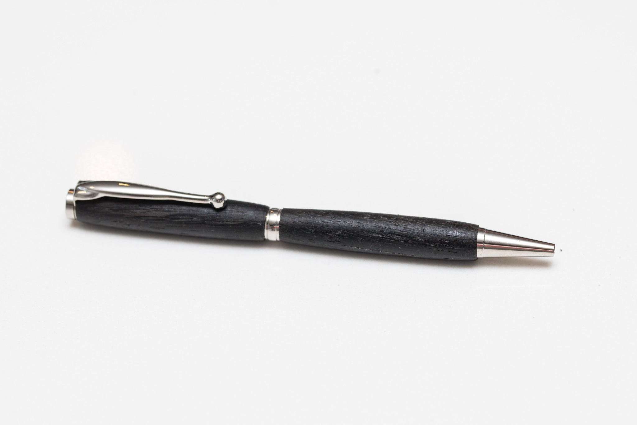 A black Irish Bog Oak wooden pen with antique rose copper fittings, displayed against a white background.