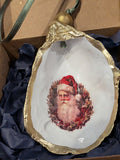Decorative ornament with a gold rim featuring a portrait of Santa Claus on a white background.