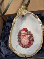 Decorative ornament with a gold rim featuring a portrait of Santa Claus on a white background.