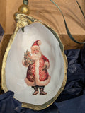 Decorative shell with a painted Santa Claus figure on a wooden surface.