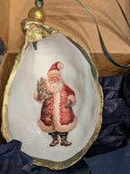 Decorative shell with a painted Santa Claus figure on a wooden surface.