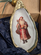 Decorative shell with a painted image of Santa Claus on a blue fabric background