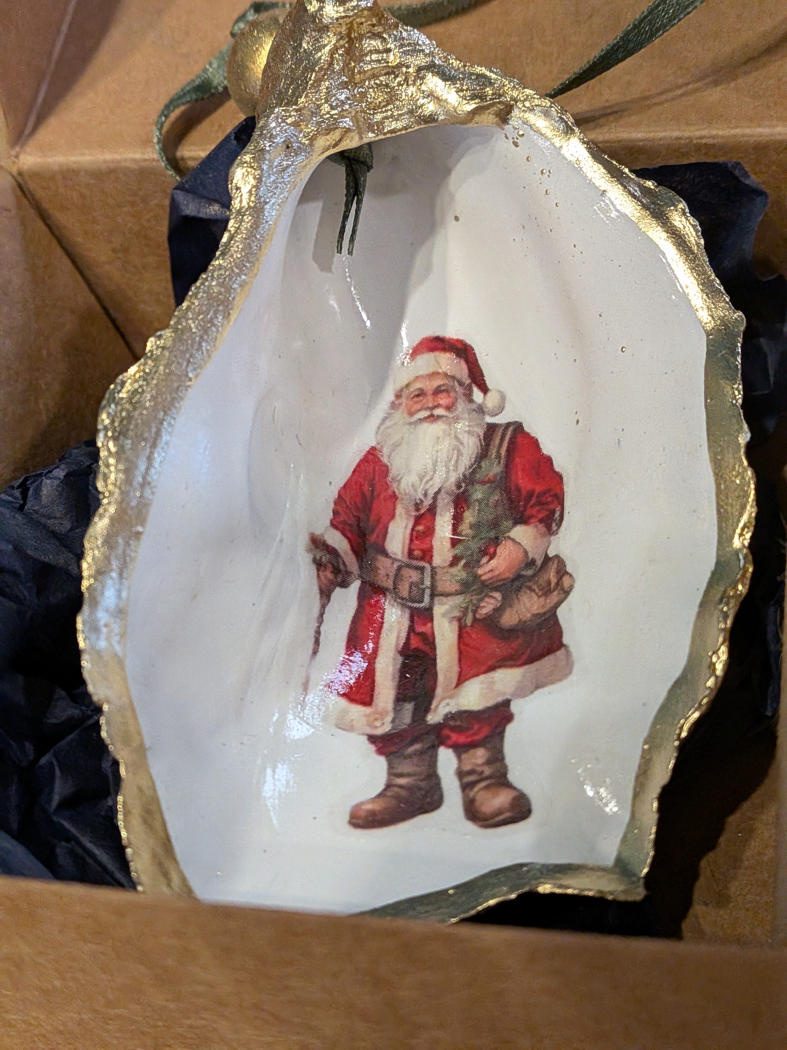 Decorative shell with a printed image of Santa Claus inside, displayed against a brown background.