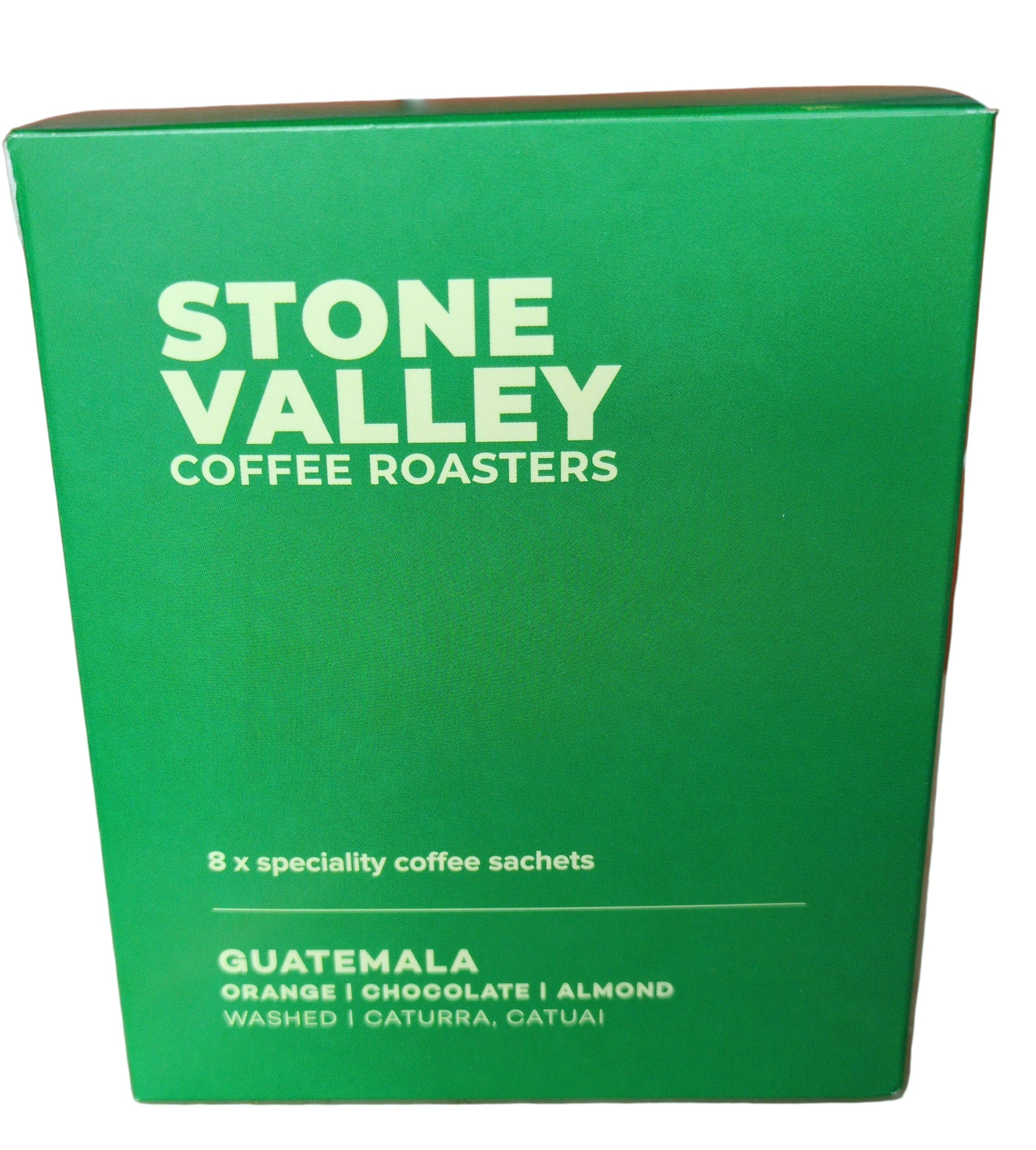 Green package of Stone Valley Coffee Roasters Guatemala coffee on a tiled floor.